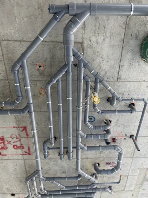 Overhead drainage branches and suspended pipework in a concrete building