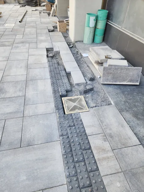 Linear drainage channel beside exterior paving