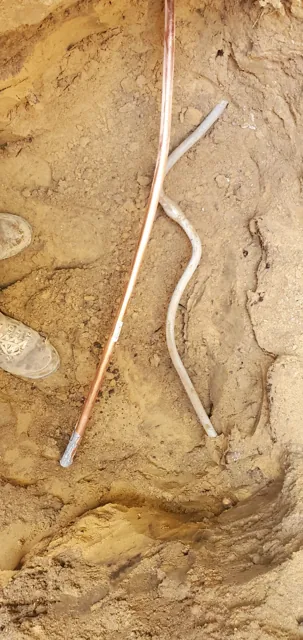 Water-service piping exposed within an excavated area